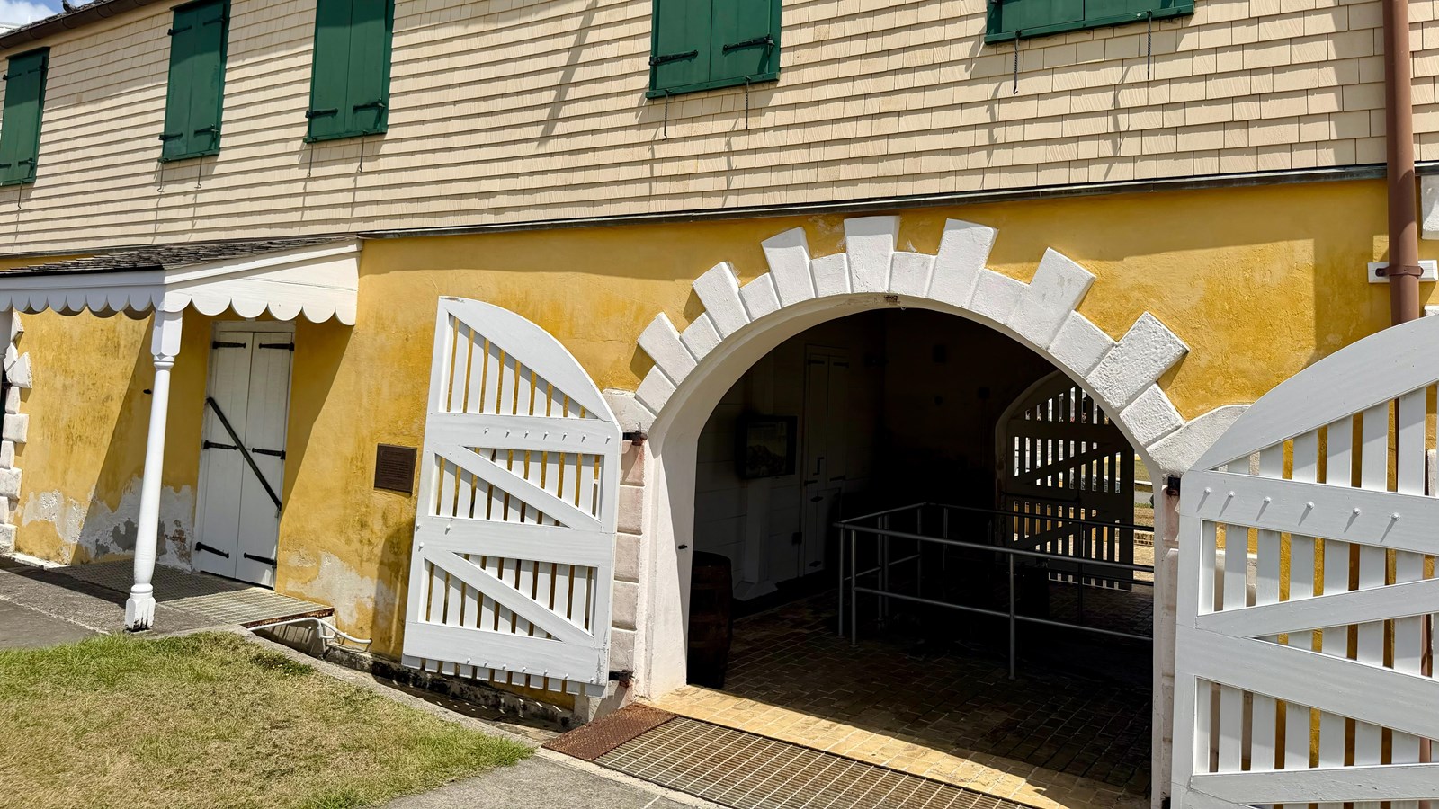 Yellow building with a scale and green shutters