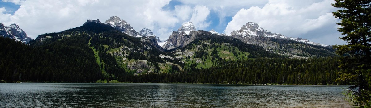A mountain range rises out of a lake.