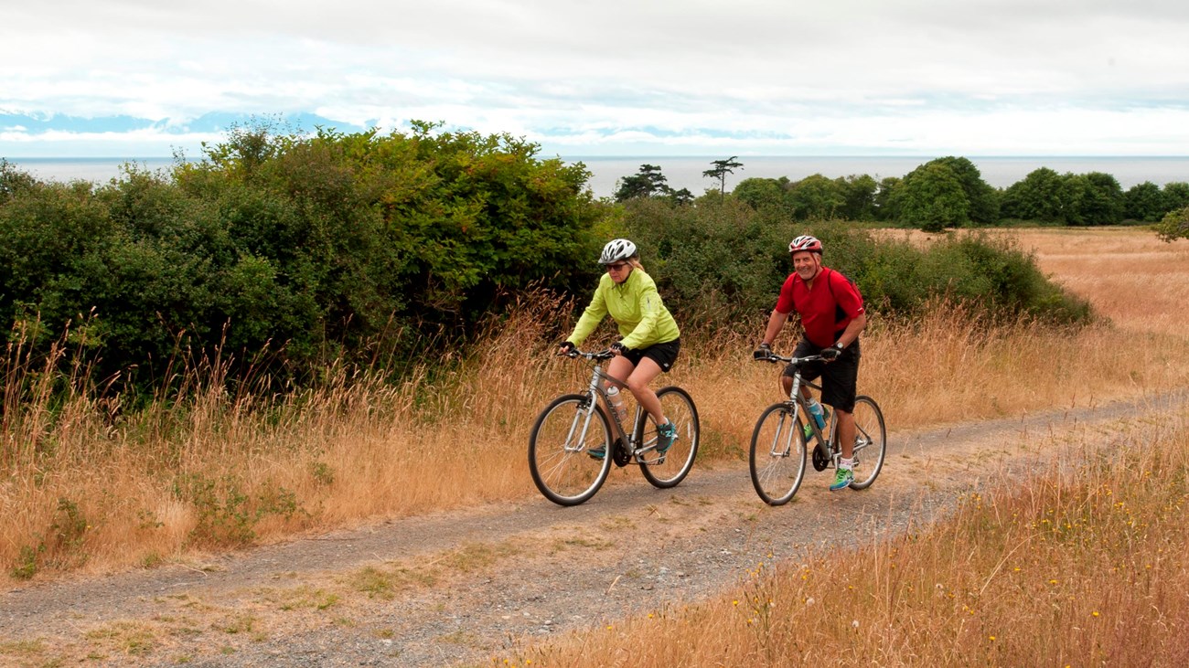 Two bikers traveling on a dirt road