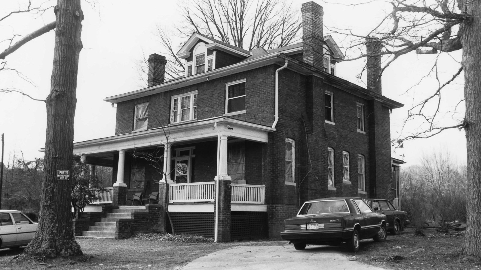 Two story brick house with front porch and balcony