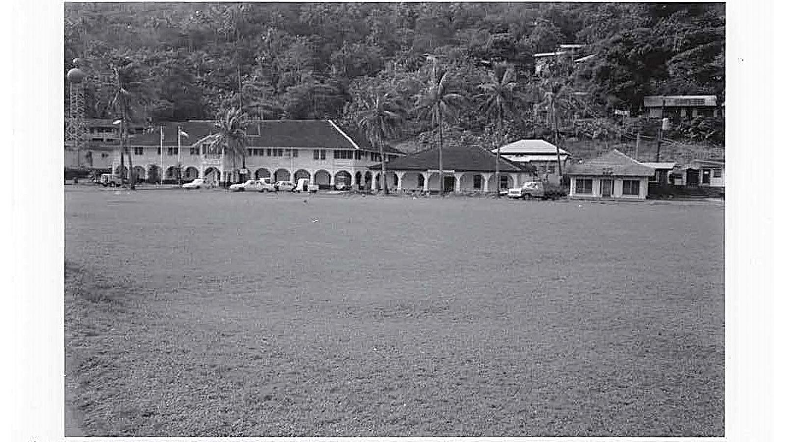 Parade ground with three buildings lining the backdrop of the photo.