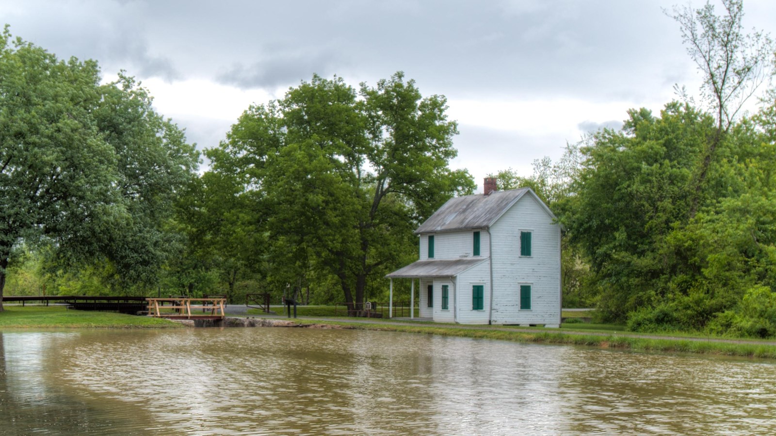 Water runs towards a lock and lockhouse. 