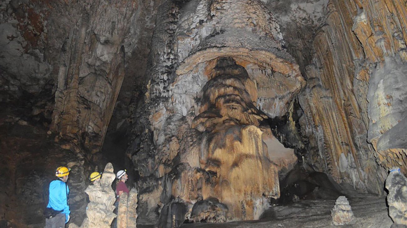 Photo of the Mushroom cave formation with visitors in the Slaughter Canyon Cave.