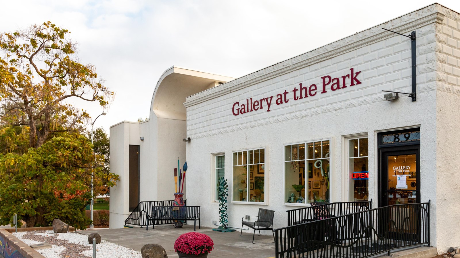 Color photo of a white one-story brick building with “Gallery at the Park” in large letters.