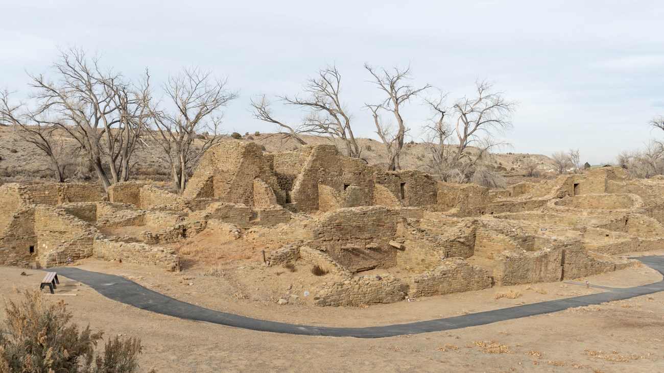 A photo of the Great House with a blacktop trail in the foreground.