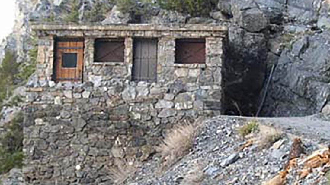An outhouse on the edge of a trail overlooking a cliff edge