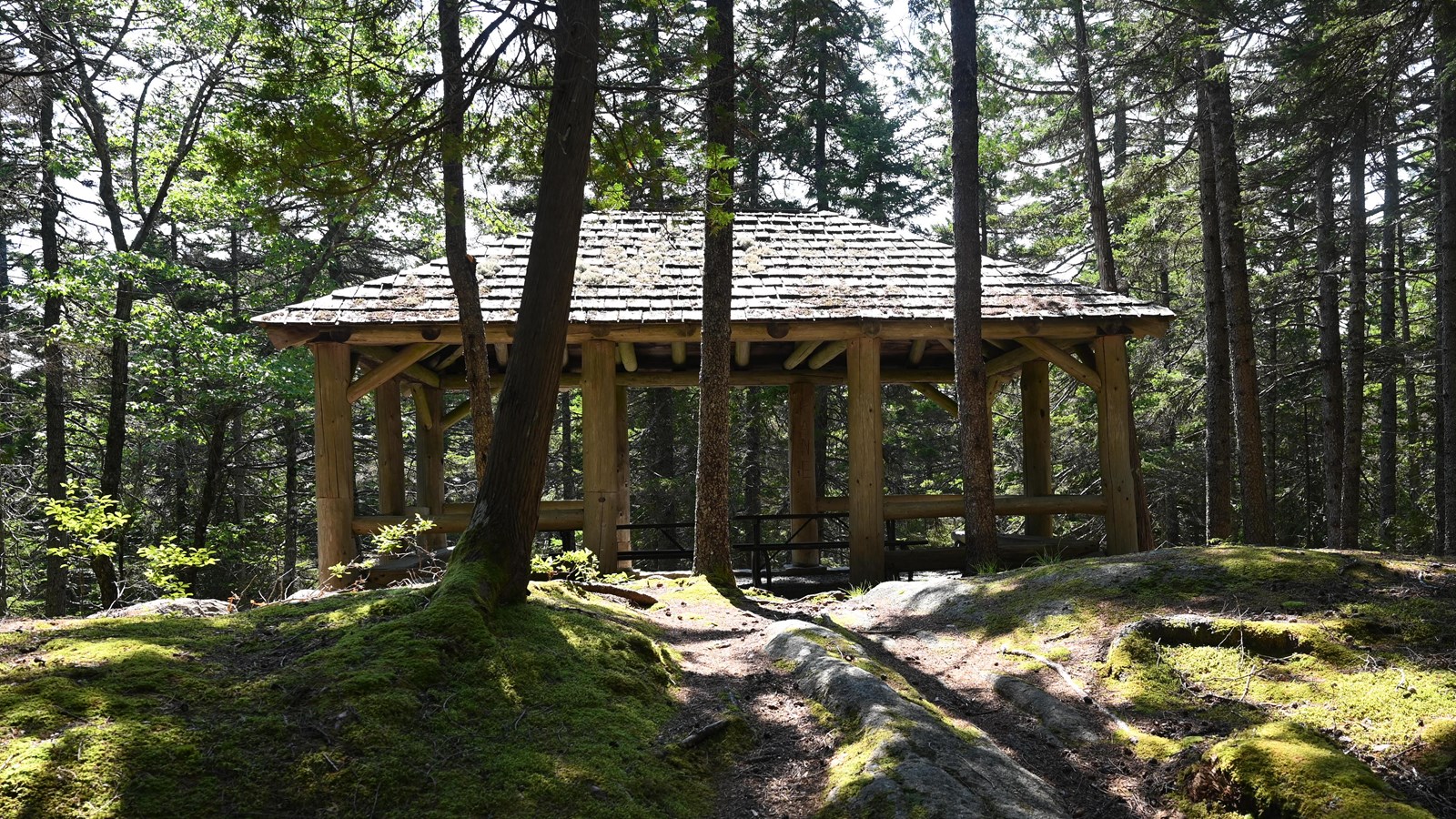 uphill and uneven walk to a wooden picnic pavilion with two tables