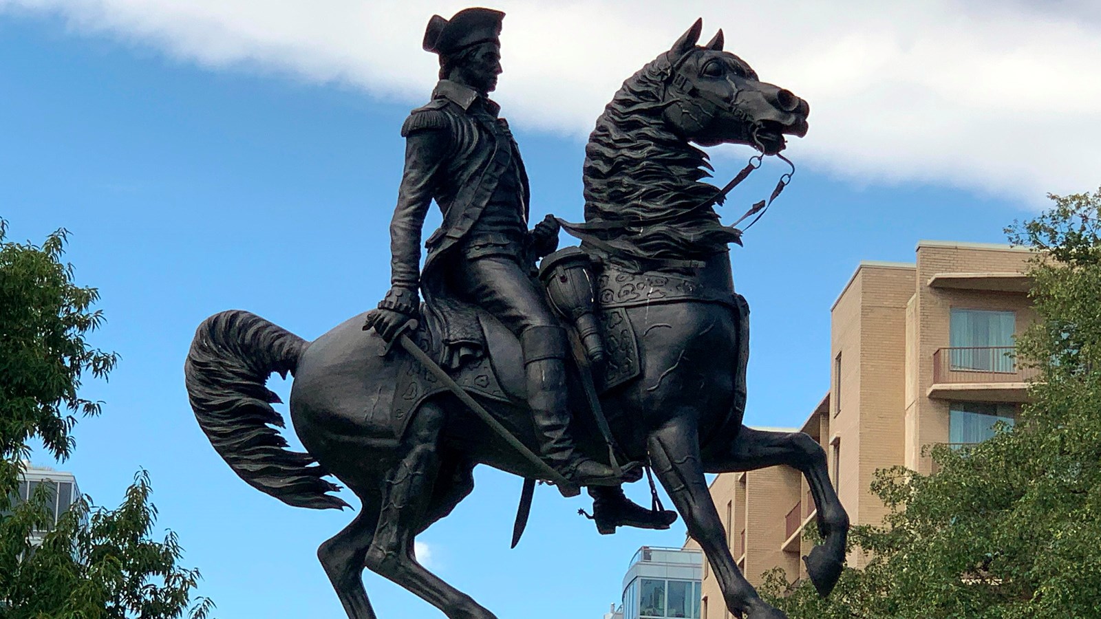 Bronze statue of a man in military uniform on a horse