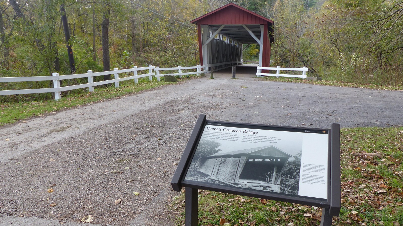 Graphic panel shows a historic photo of the red and white covered bridge beyond.