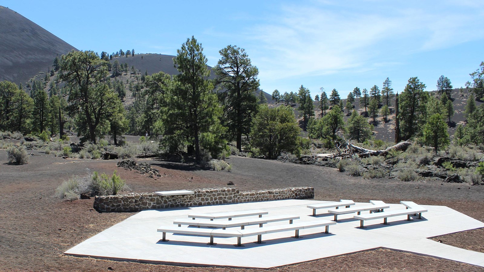A concrete slab with fixed benches built on top of loose volcanic cinders.