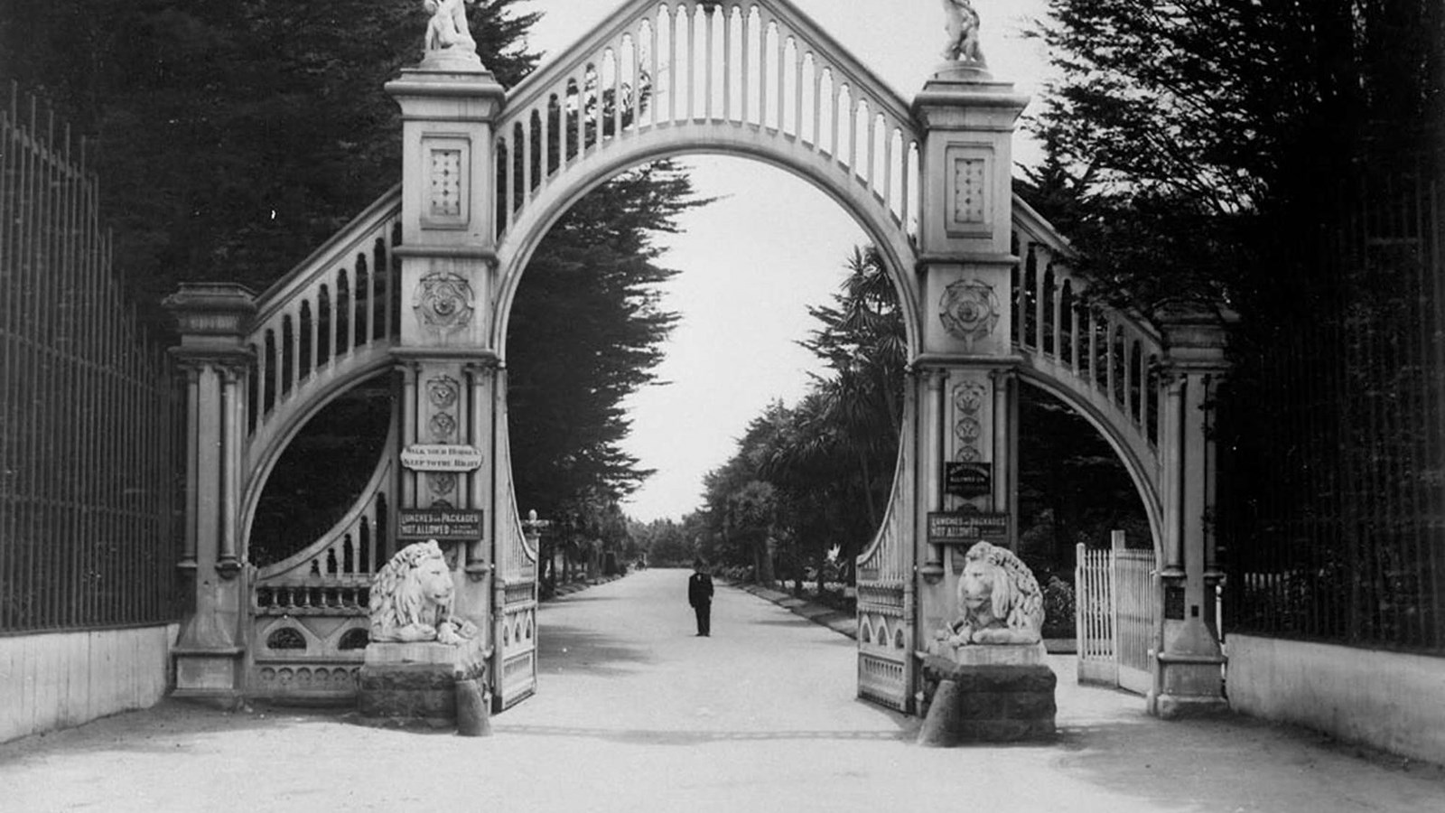 The ornate columned gate at the entrance to the historic Sutro Heights stretches across a wide path.