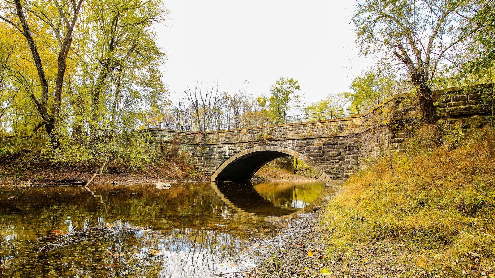 A single arch aqueduct spans a creek.