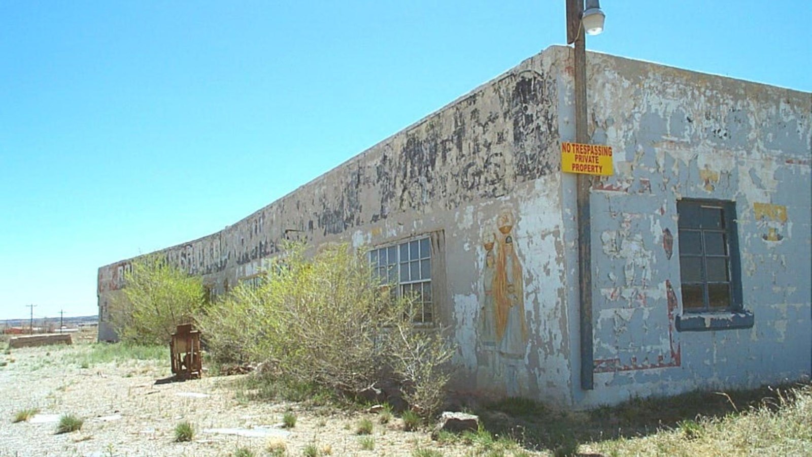 A large stucco building with very faded colorful paint on the exterior