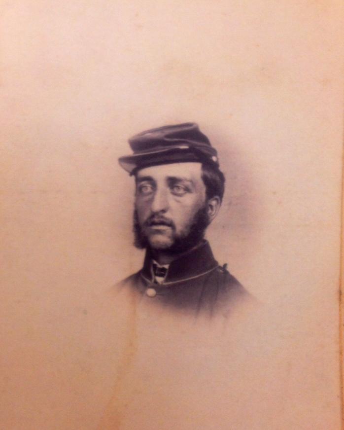 A Civil War era portrait photo shows a US Army officer in uniform, his bust in a fade. 