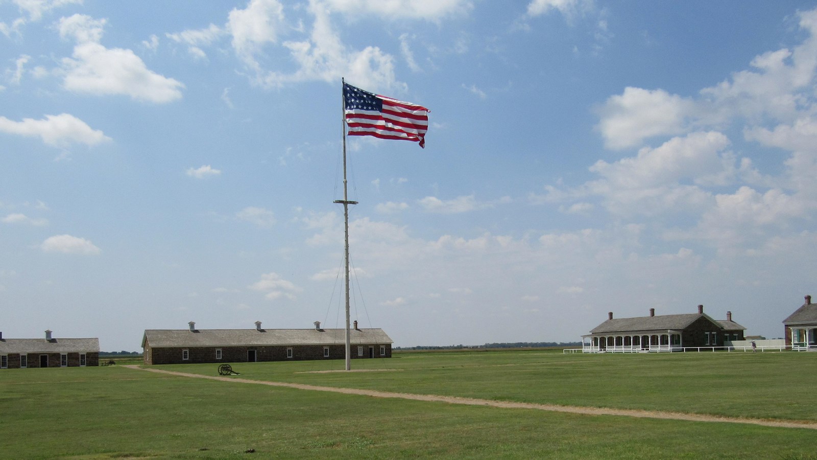 99-foot tall flagpole in the middle of open, grassy area, with large flag flying at top.