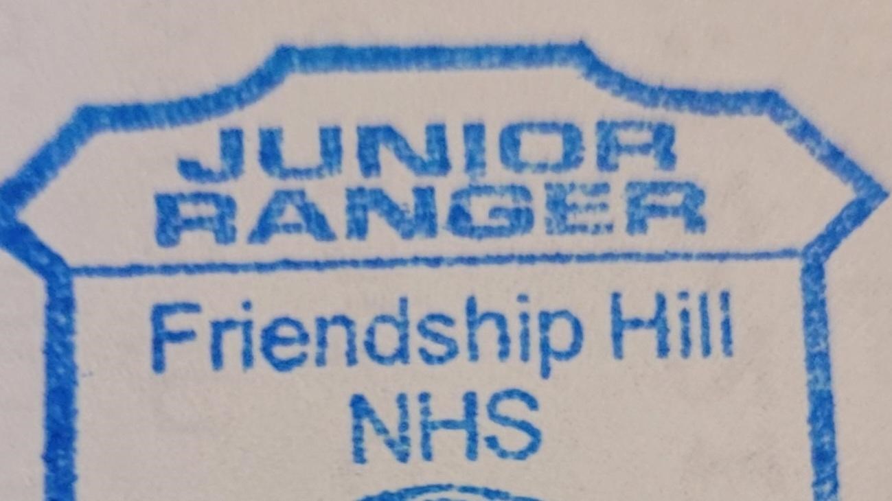 Badge shaped stamp reading Junior Ranger Friendship Hill NHS