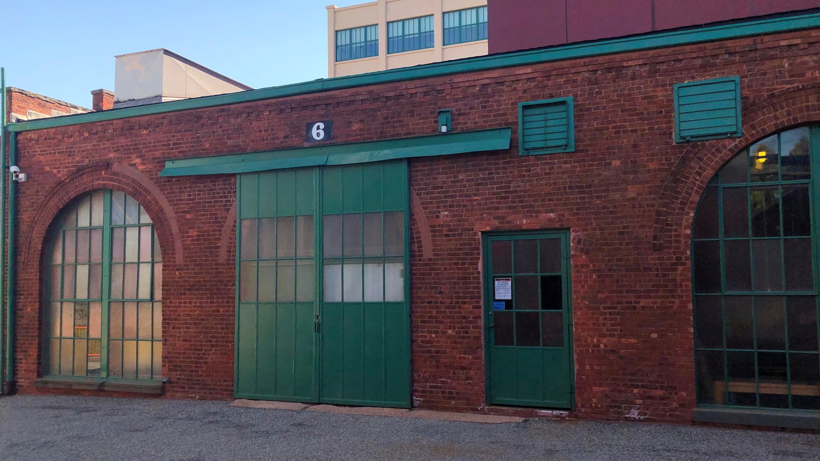Long rectangular one story red brick building. sky in background
