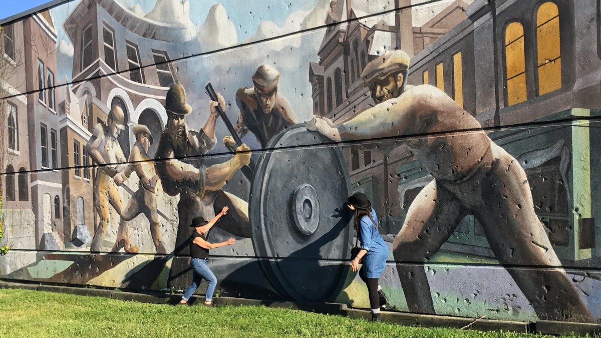 A mural showing Pullman factory workers and Pullman cars