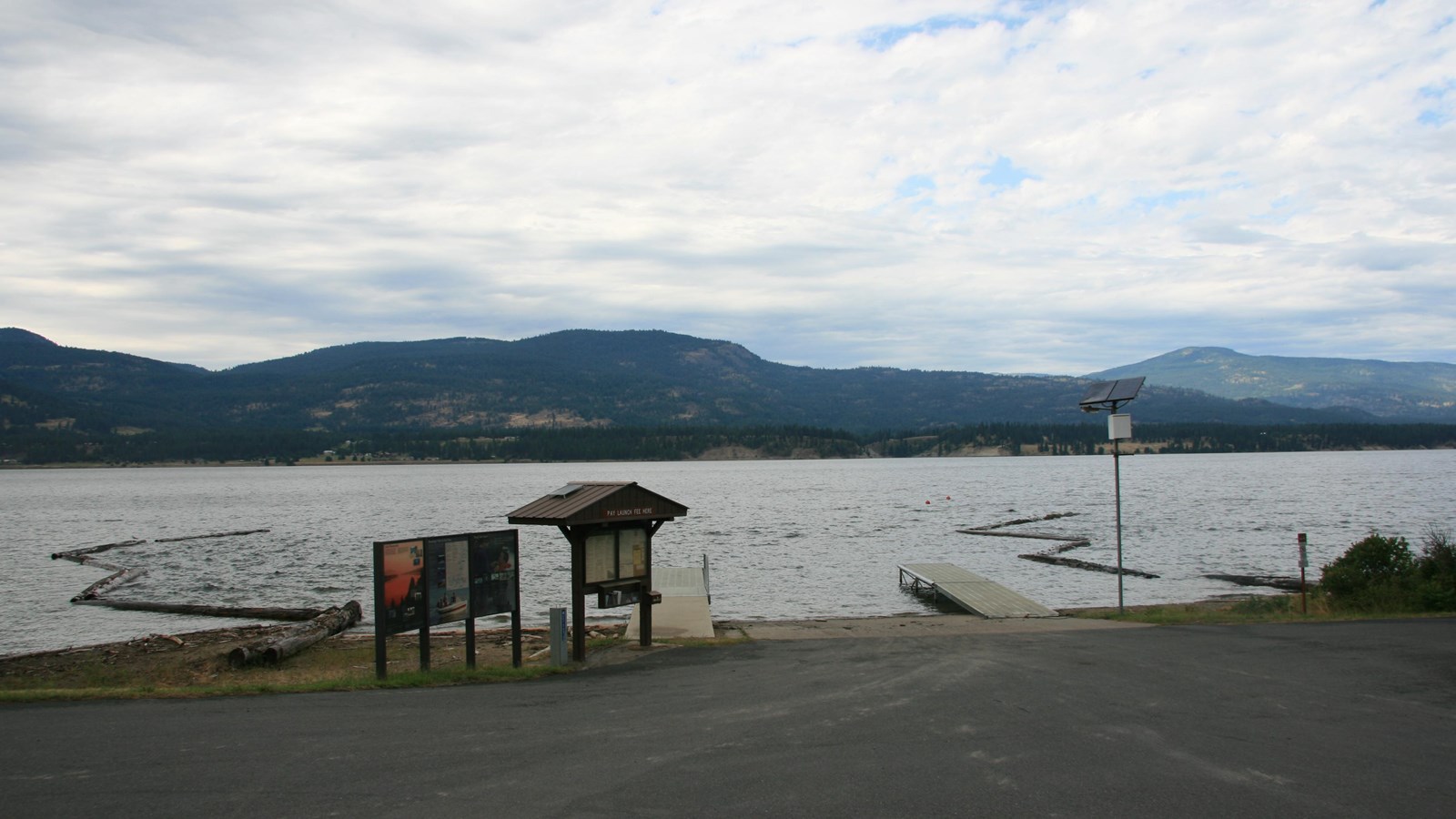 The paved parking area leads to the boat ramp, with the information kiosk directly adjacent.