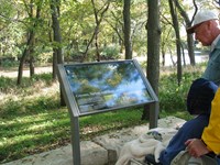 Visitors viewing one of the waysides along the Bottomland Nature Trail.