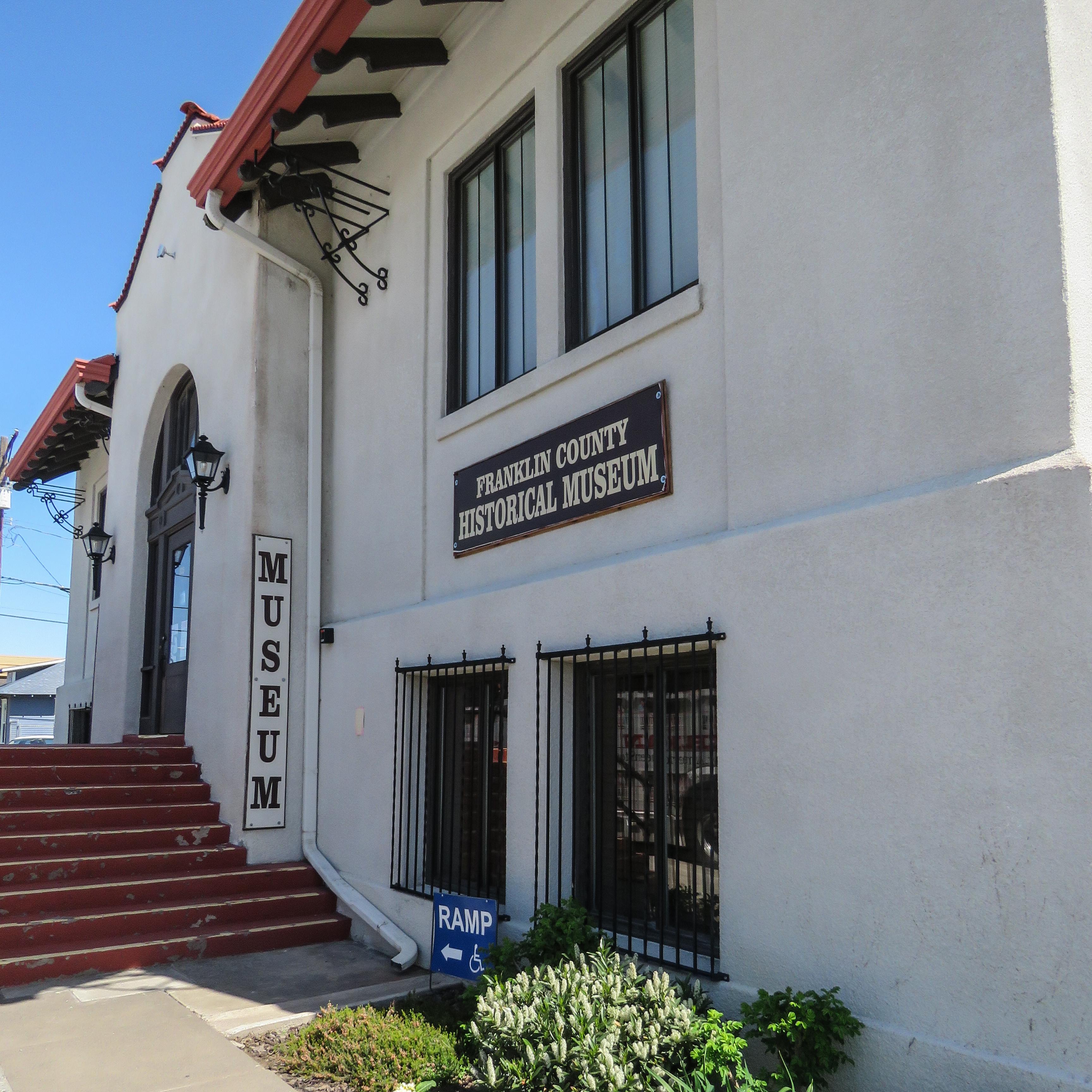Color photograph of a solid white structure. A sign reads “museum” near the entrance.