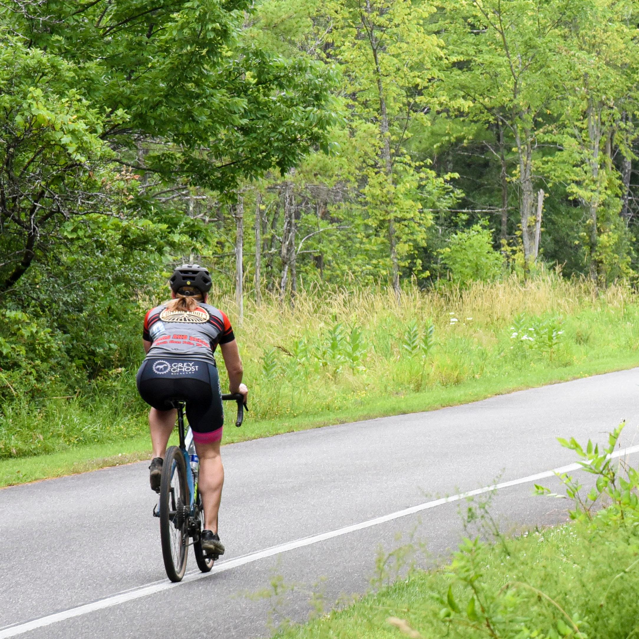 Single cyclist using the bike lane of a paved road while wearing proper safety gear