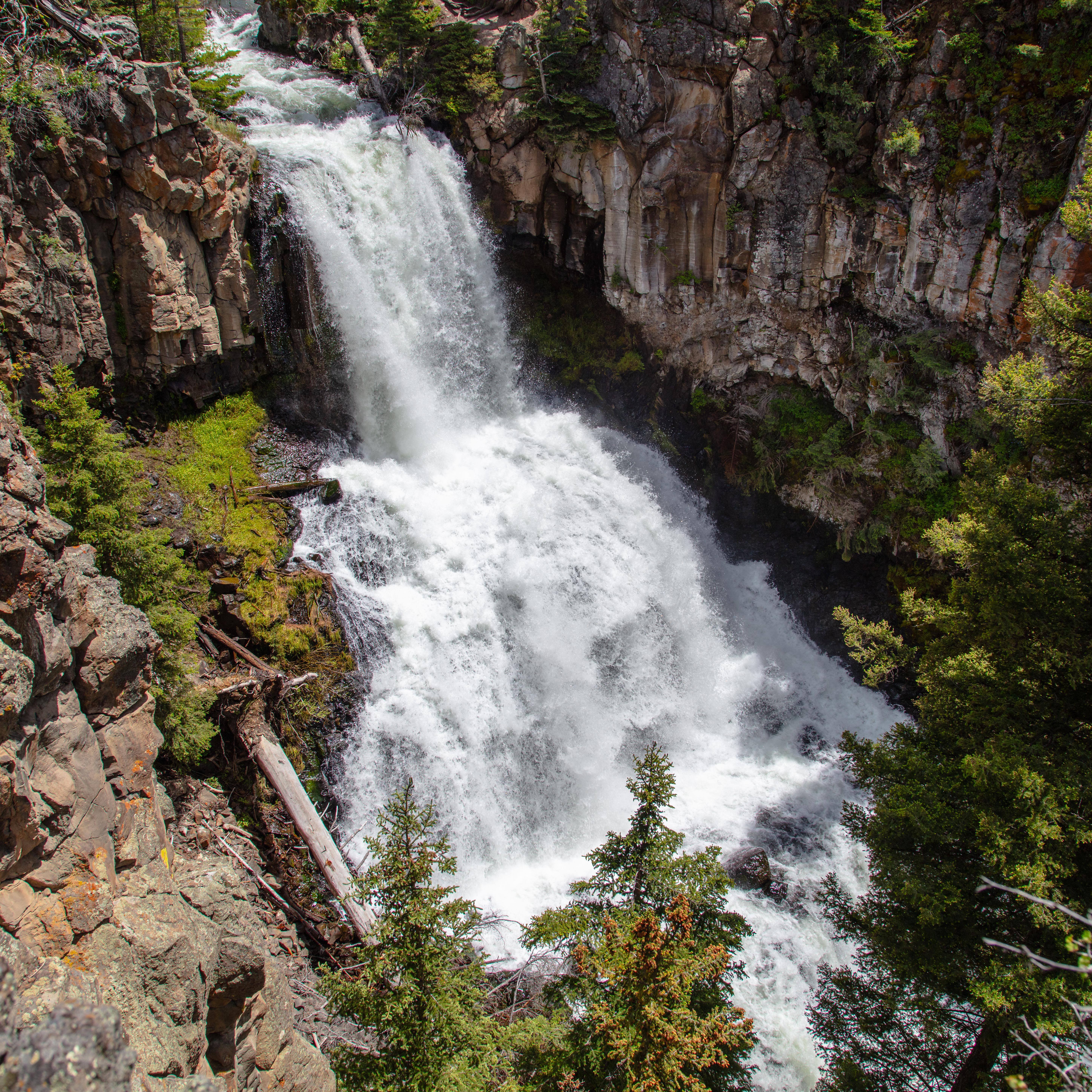 A two-tiered waterfall surrounded by columnar basalt as viewed from above.