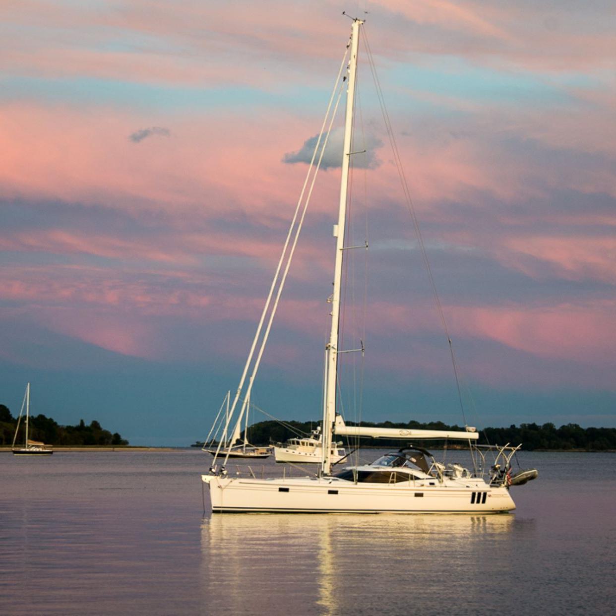 Sailboat underneath a cotton candy sunset sky. 
