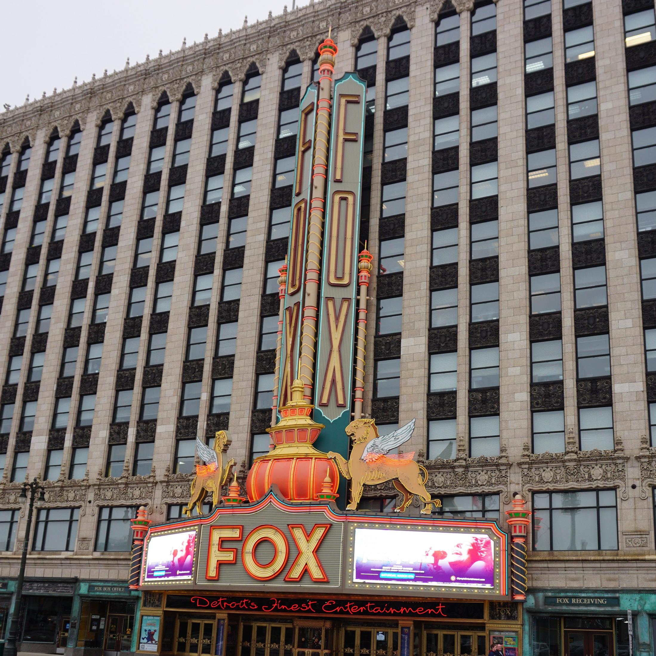 Neon sign in front of art deco building. 