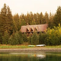 a large building in a forested area on a beach
