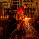 A blacksmith working inside the Blacksmith Shop at Fort Vancouver.