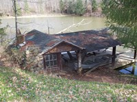 A wood and stone covered boat launch jutting into a lake.
