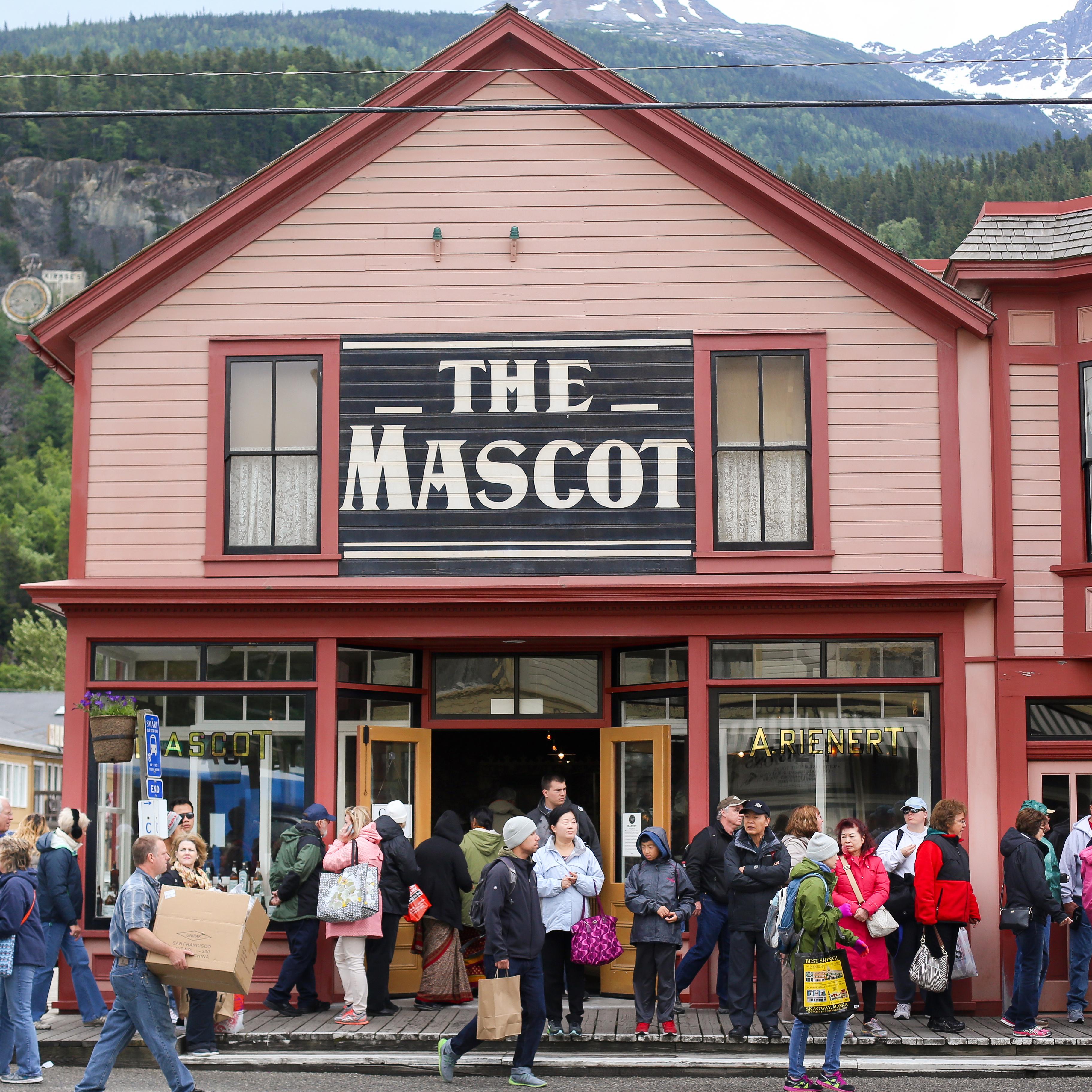 People in front of a brightly colored building with sign 
