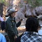 A ranger gives a program along a paved trail near a sequoia