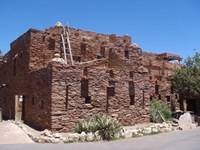 A two story red brick building with southwestern native american elements