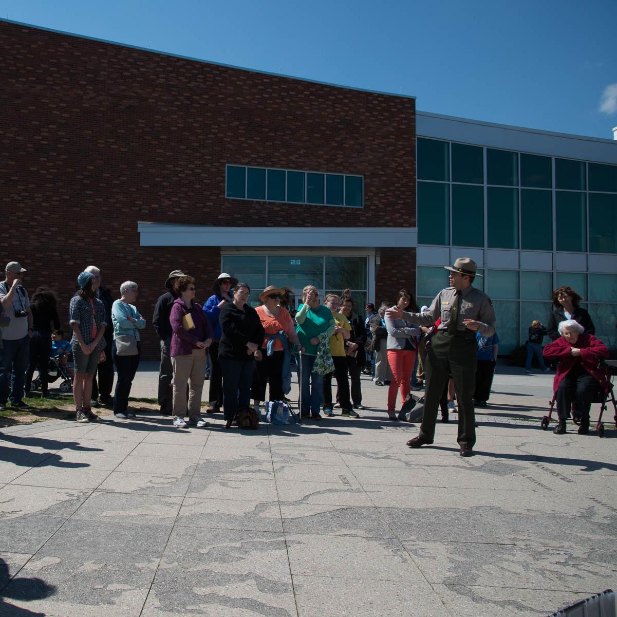 A ranger speaks to a crowd outside the Fort McHenry visitor center.