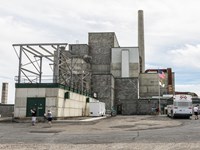 Color photograph of a very large industrial building composed of stacked concrete cubes