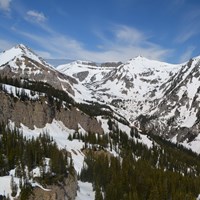 A mountainous canyon covered in patchy snow.