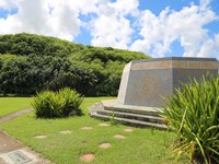 A low, six-sided concrete memorial. The side facing the camera says "and gallent effort"