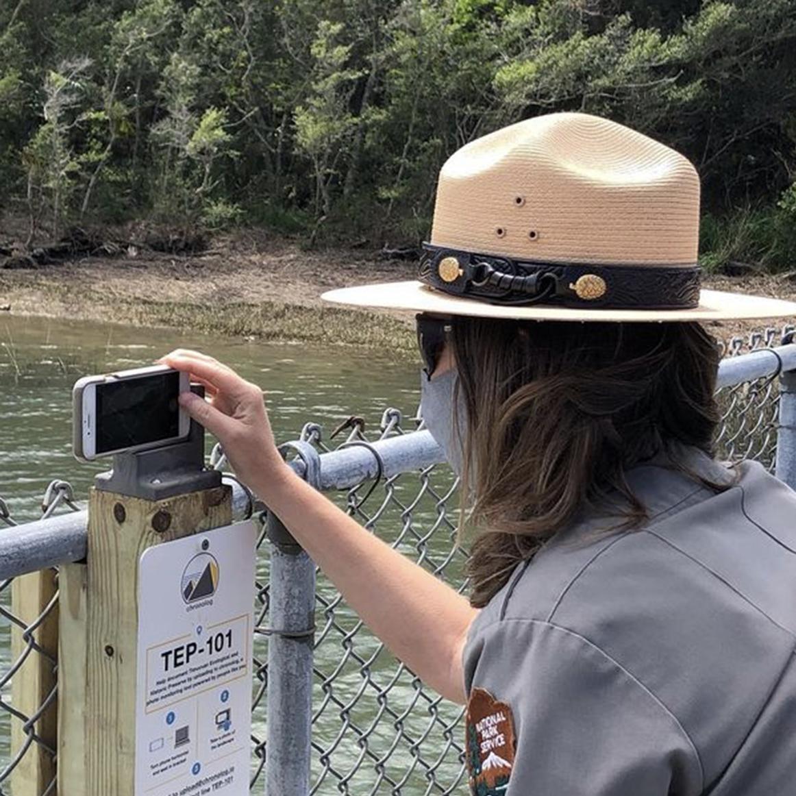 a ranger takes a photo on the dock