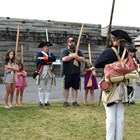 A family group stands in line with Continental Soldiers, practicing their march.