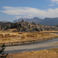 A creek meanders past a rocky outcropping.