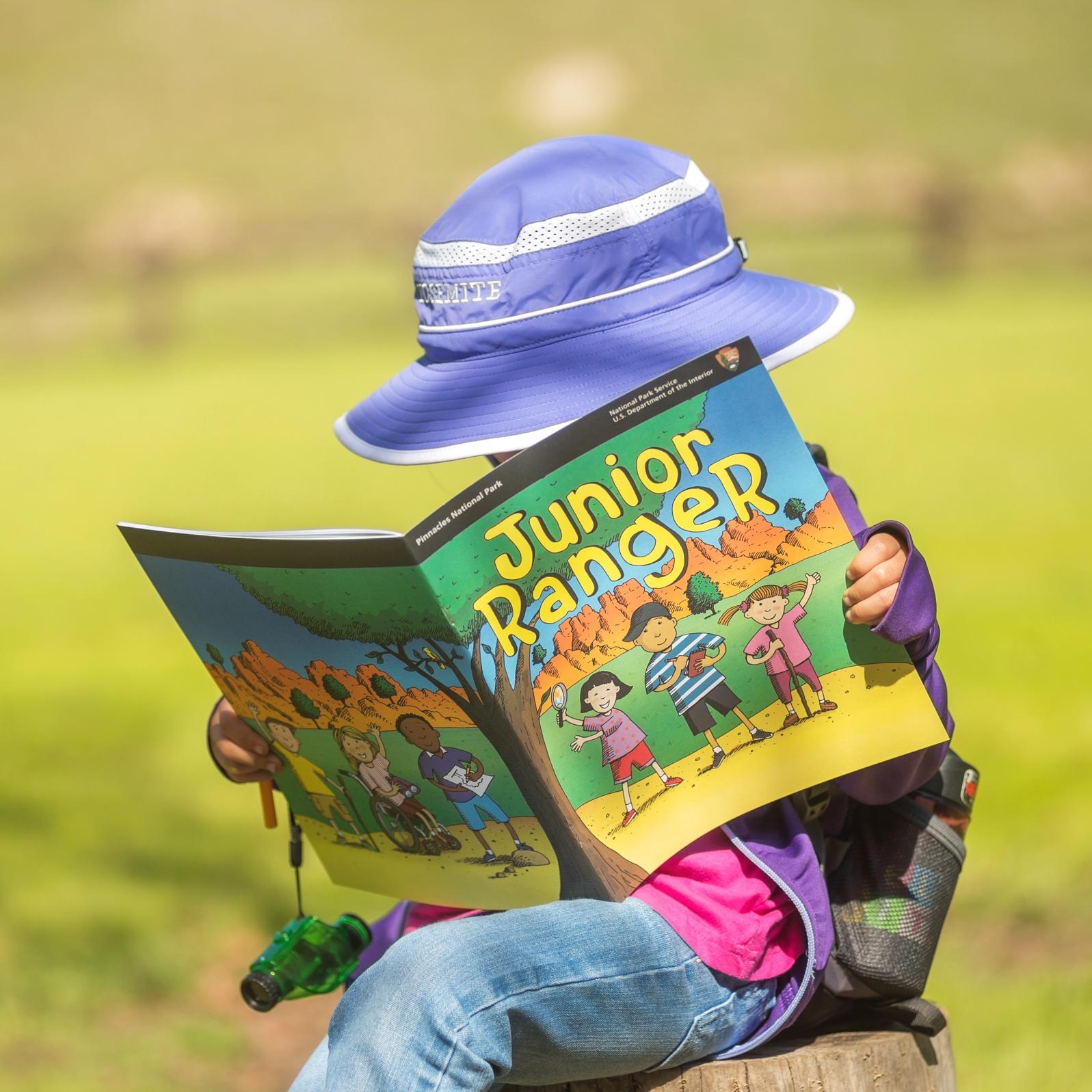 A child looking at a Junior Ranger booklet
