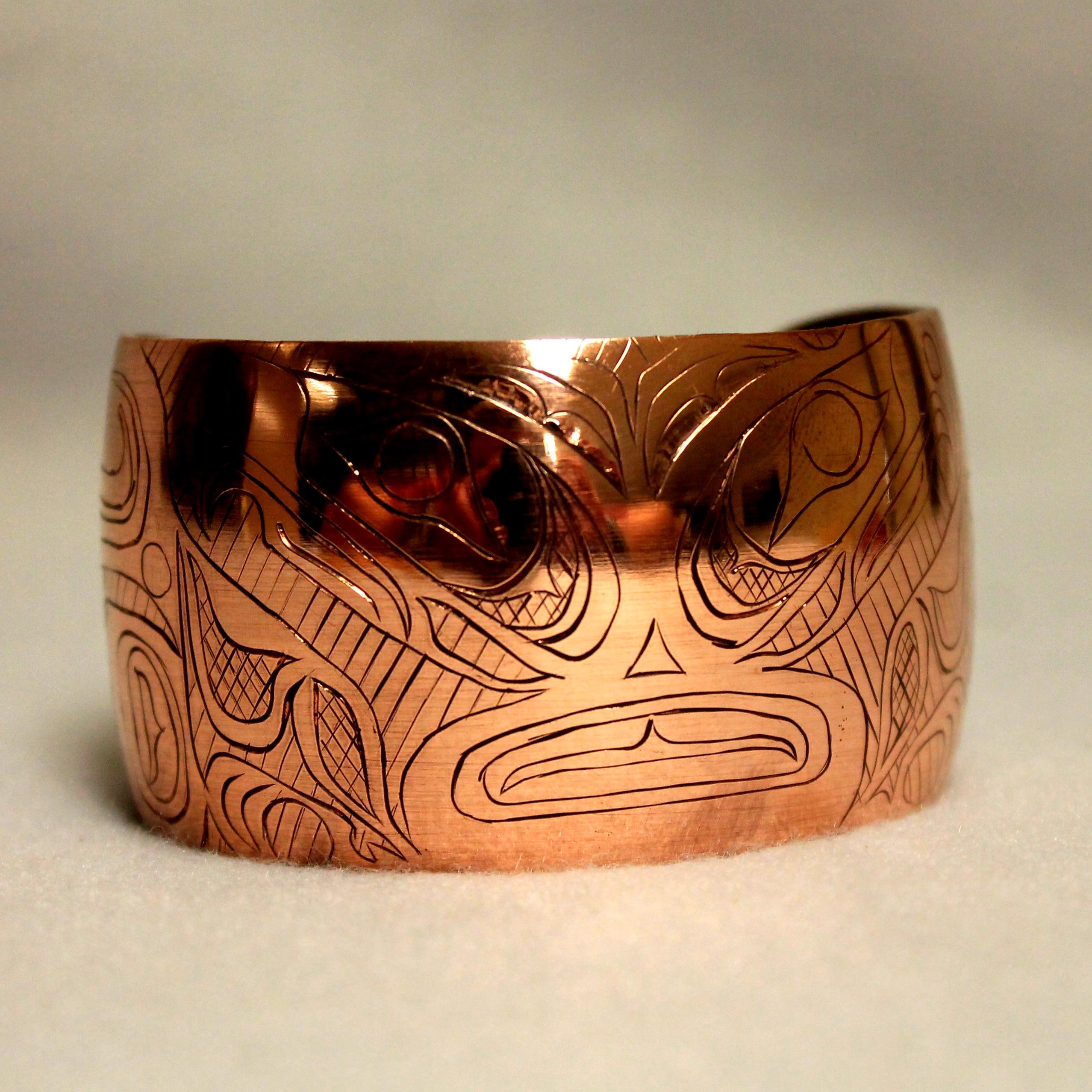 A copper bracelet with stylized engraving 