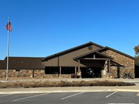 A large, brown stone building, with an awning over the front door.