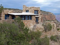 A multi-level white stone building perches right on the edge of Grand Canyon.