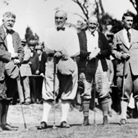 a black and white image of four men wearing dated golfing attire
