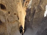 Ranger Climbs out of the Rings Trail. Ranger is in-between tall and narrow cliff walls