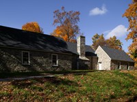 Fieldstone house on the crest of a broad hill.