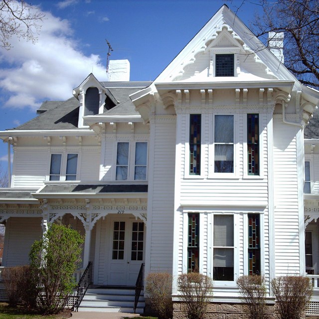 A two-story white painted house with gabled roof.
